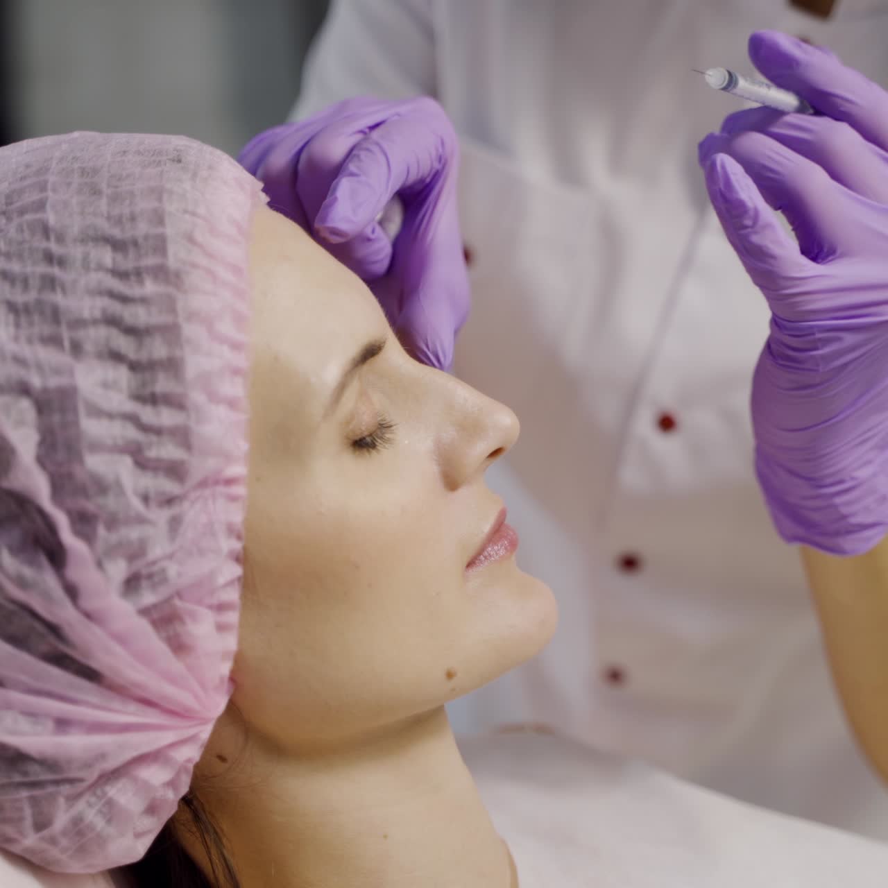 An experienced cosmetologist makes botox in the eyebrow area for a woman. Facial skin rejuvenation. Cosmetology. Side view