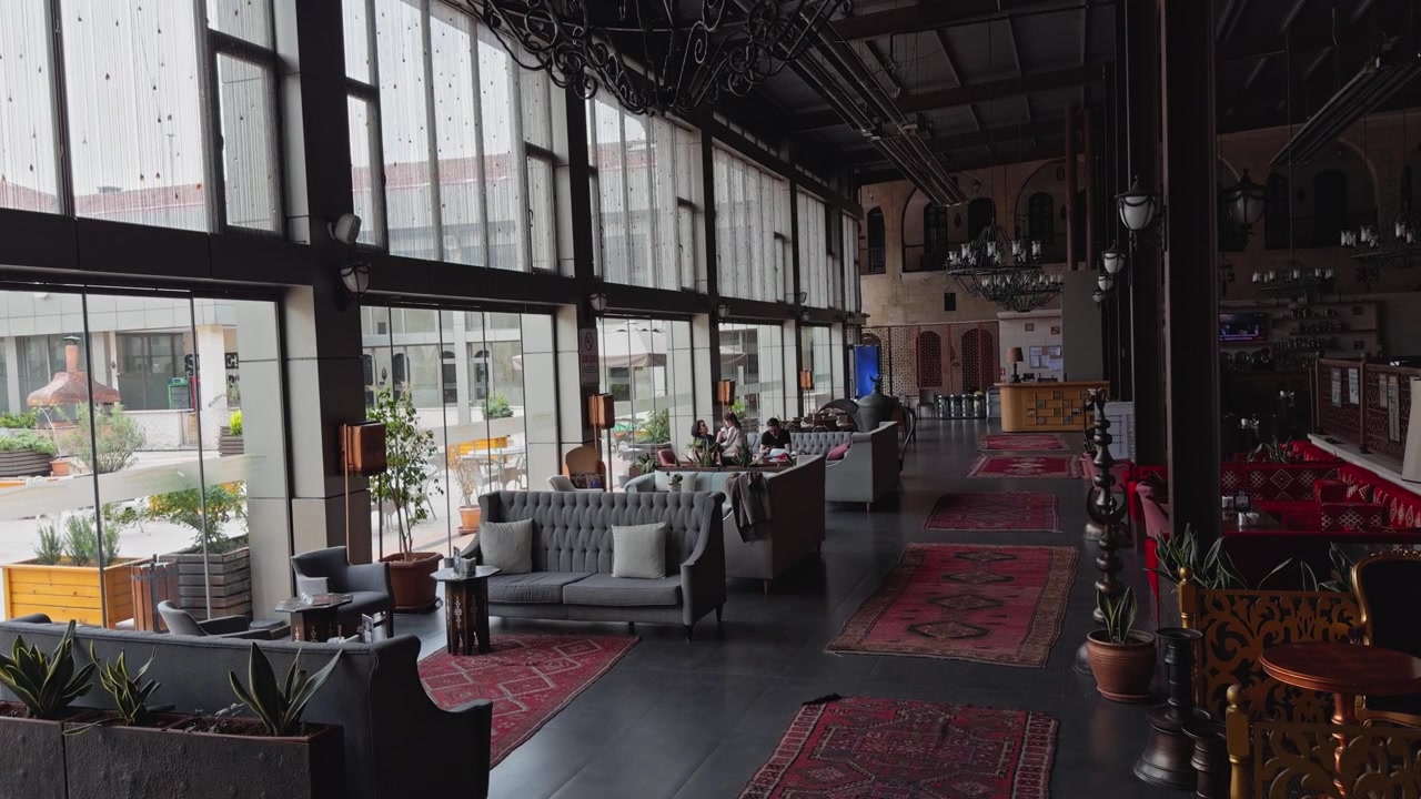 Una ripresa all'interno dell'Hotel Sirehan, un caravanserraglio restaurato dell'era ottomana a Gaziantep, Turchia, con archi in pietra, balconi in ferro e un caffè nel cortile.