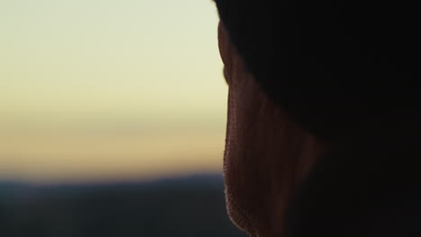 silhouette of a gentleman looks at sunset sky in winter outdoor