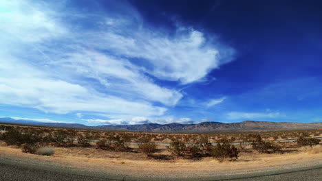 watching the scenery along a desert highway on a picturesque day with mountains in the distance - passenger point of view