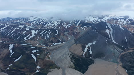 Birds-eye-view-of-Krossa-river,-with-black-volcanic-ashes-flowing-in-Thorsmork-canyon-valley.-Aerial-view-of-beautiful-unique-landscape-of-Porsmork-highland-of-Iceland.-Beauty-on-earth