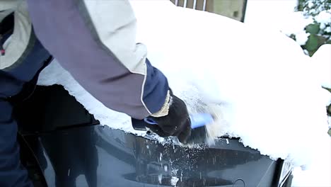 clearing snow off the cars headlights on a bright sunny day stock video stock footage