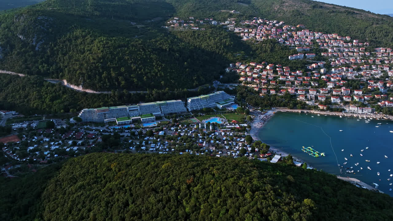 Drone descending in front of the Rabac resort, summer evening in Istria, Croatia