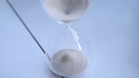 hourglass sand falling in slow motion from above