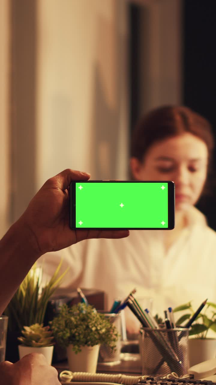 Vertical video: African american man using smartphone with greenscreen