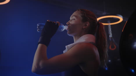 Woman taking a break in the boxing gym