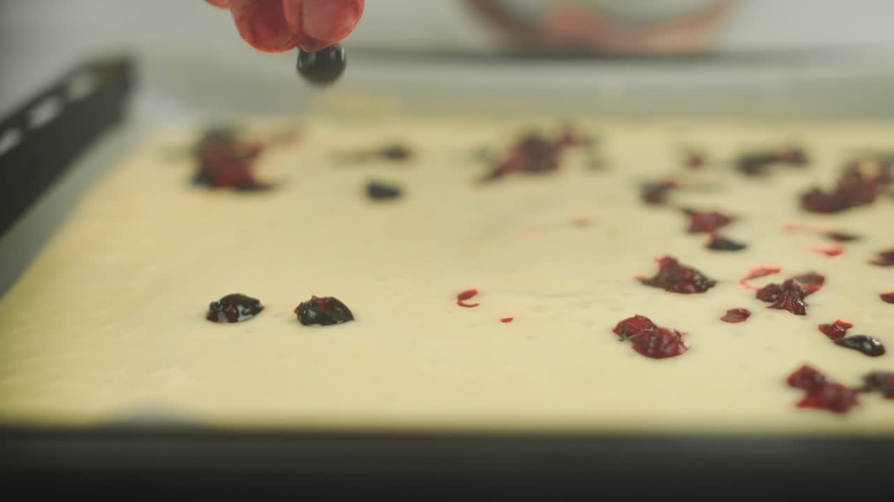 채식주의자 셰프가 케이크 반죽에 손가락으로 베리 잼과 단일 베리를 닫습니다.