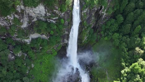 Aerial-view-of-majestic-waterfall-in-lush-Maggiatal-Vallemaggia-forest,-Ticino,-Switzerland