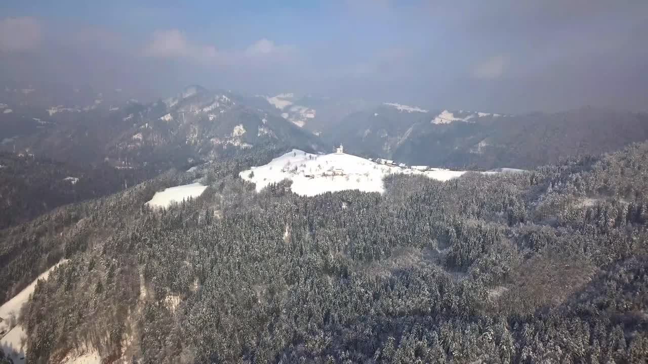 겨울 동안 중앙 슬로베니아의 언덕 꼭대기에 있는 그림 같은 스베티 토마즈 교회
