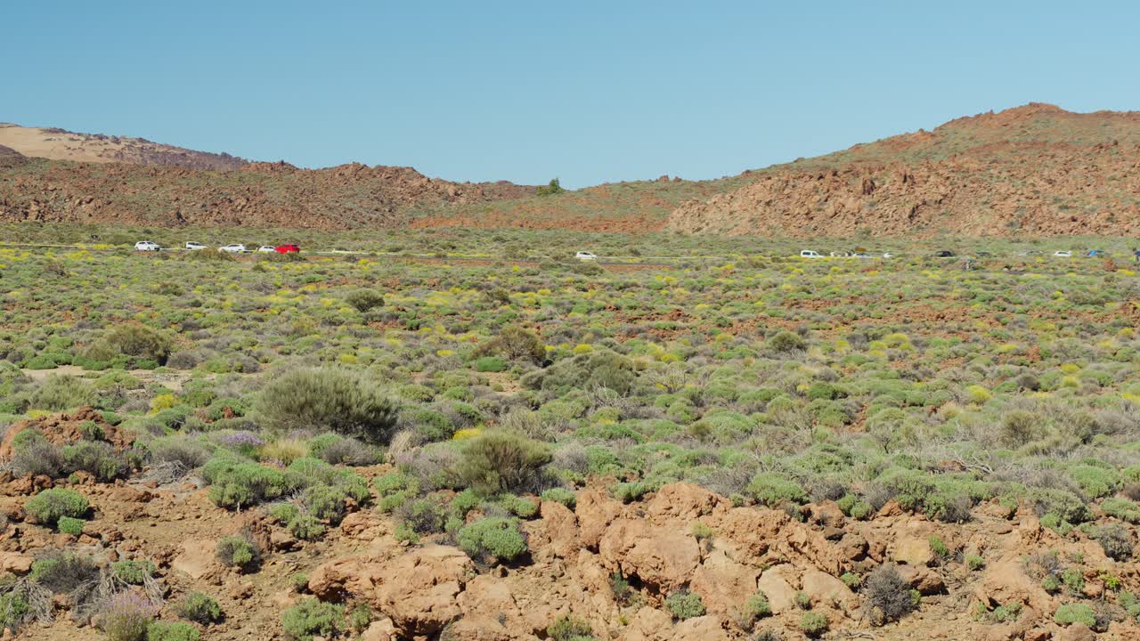 coches conduciendo en la carretera a través del desierto de la isla de tenerife, vista de mano