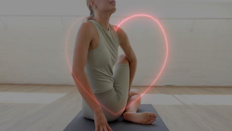 woman doing yoga pose on mat with glowing heart animation