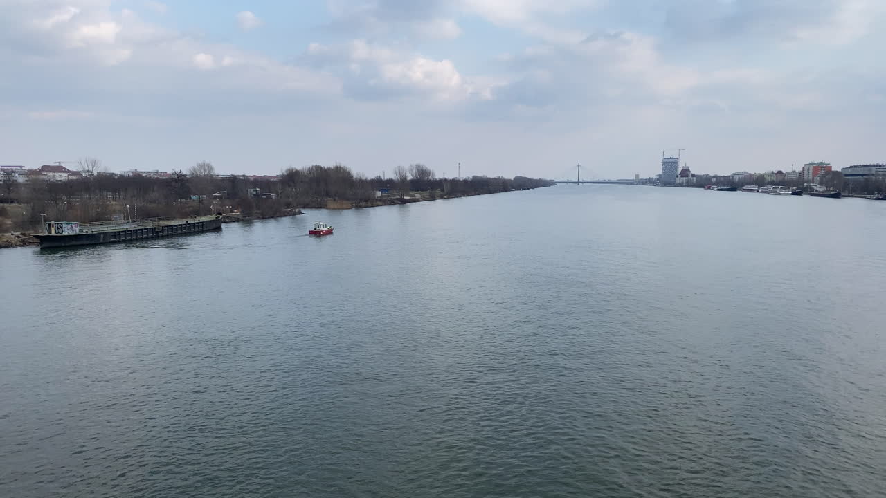 River Landscape with Boats and City Skyline