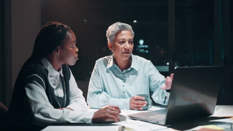 two businesswomen working late at the office