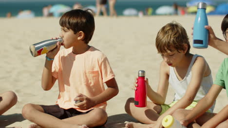 kids drinking water from returnable bottles after training