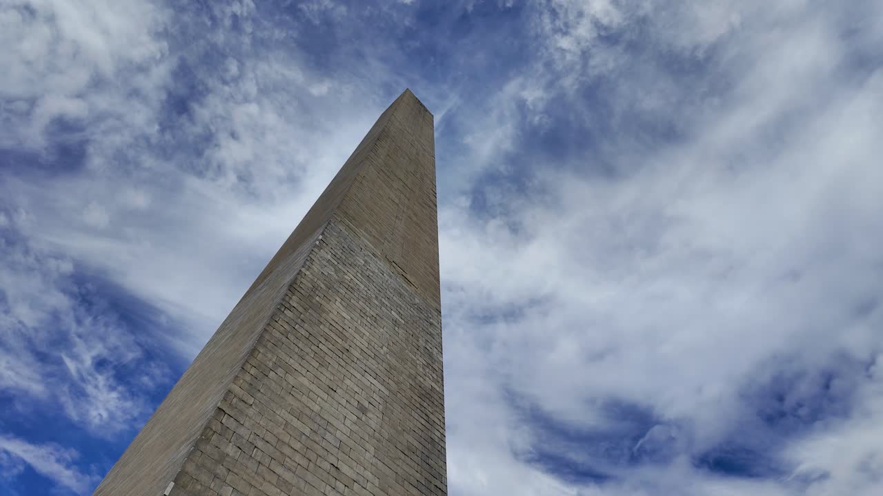 Looking up at the Washington Monument tower against blue sky with clouds, DC, USA