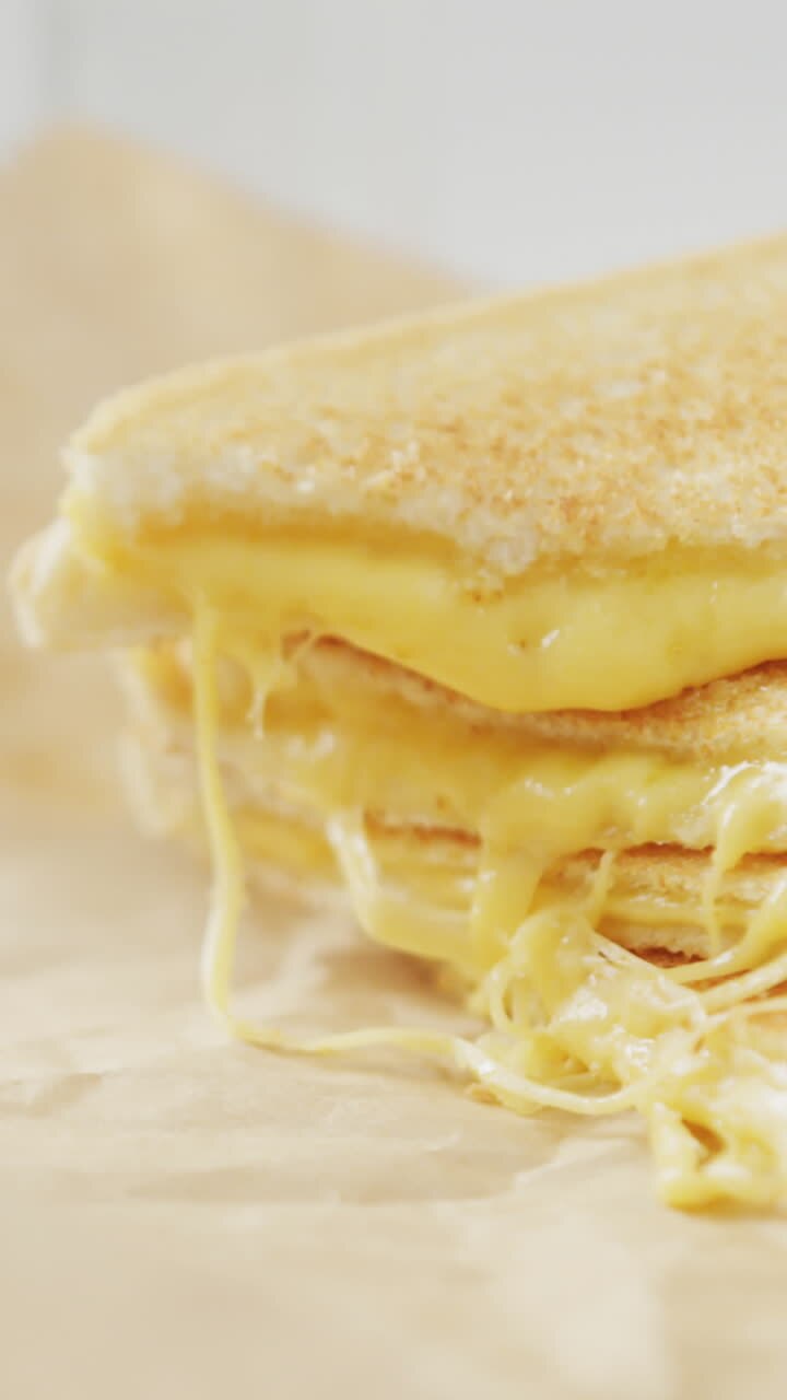 Video of slices of toasted cheese white bread sandwiches on paper and plate