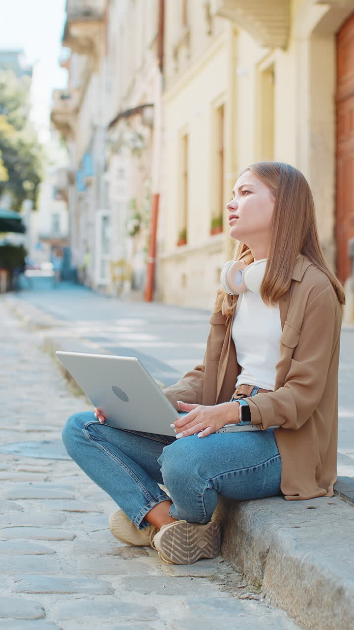 Ragazza scontenta che usa il portatile che lavora perde diventando sorpreso dal risultato improvviso della lotteria all'aperto