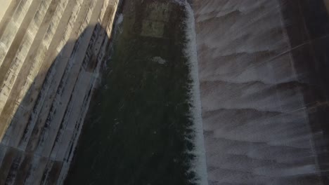 toma aérea que viaja a través del embalse de la presa asprokremmos mientras el agua se derrama durante una sobrecarga de la presa