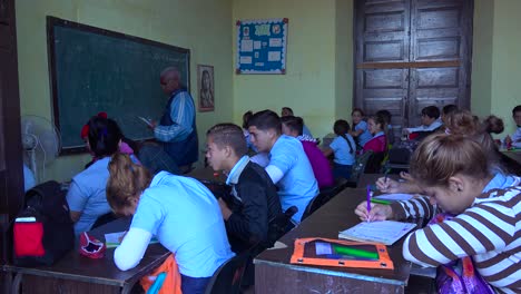 Estudiantes-Estudian-En-Un-Aula-En-Cuba-Mientras-Un-Maestro-Mira-1