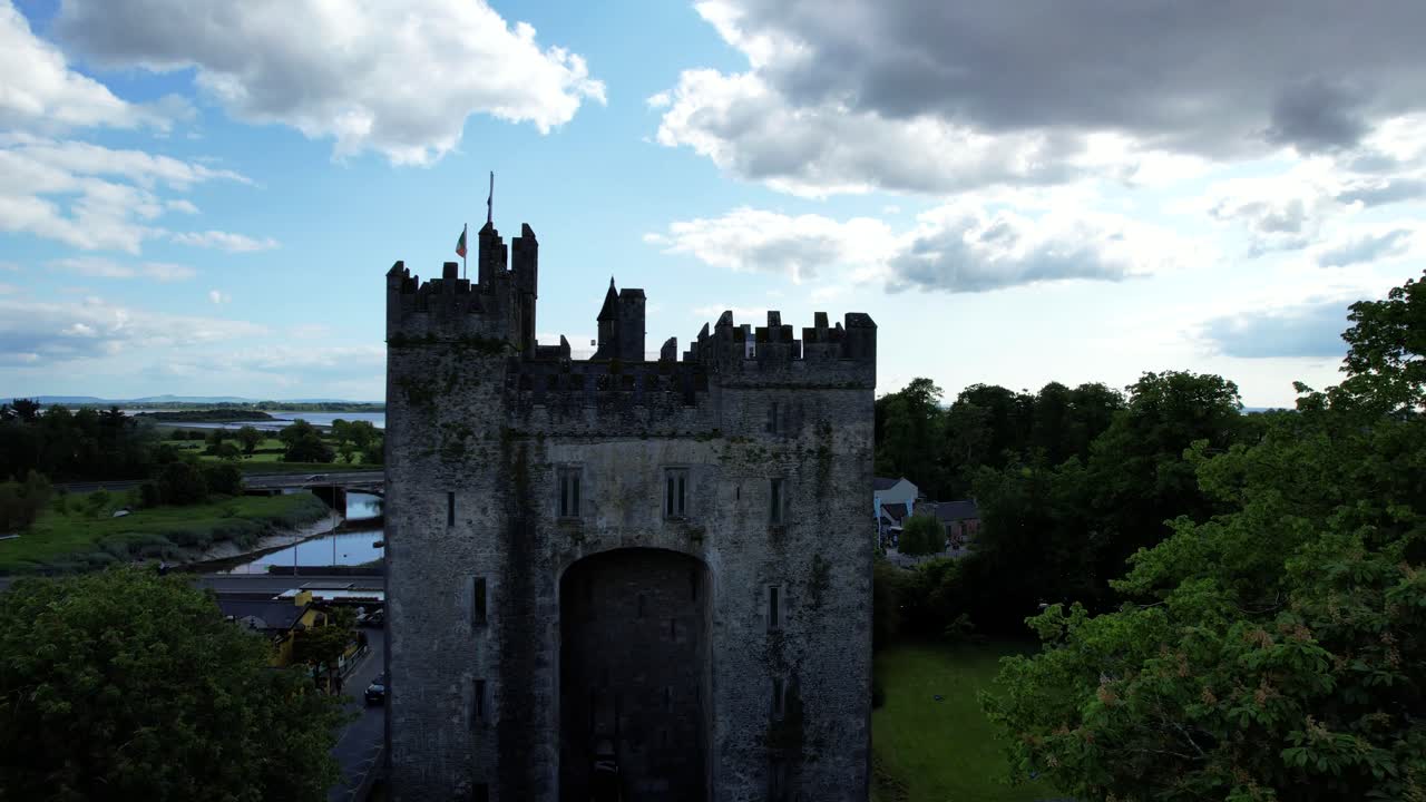 el castillo de bunratty entre los árboles del parque popular en irlanda, el océano atlántico en el fondo