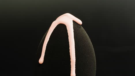makeup sponge with dropping pink liquid