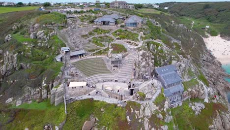 minack theatre with porthcurno in the background, aerial drone shot, cornwall, uk