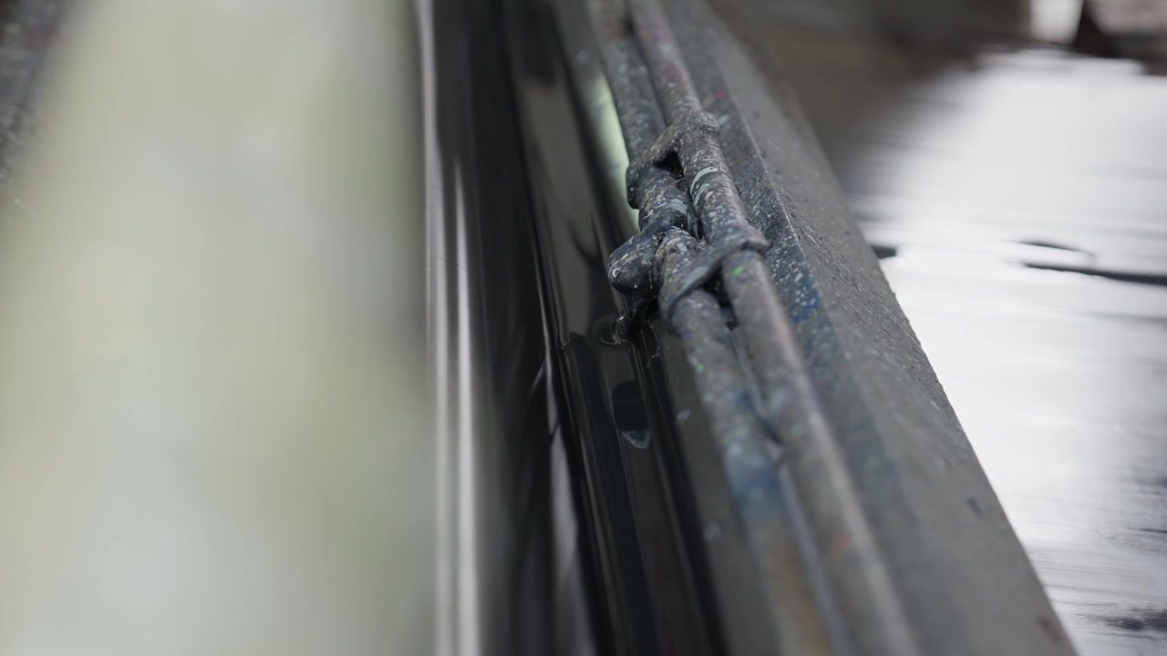 Agente chimico conciante che fuoriesce da una macchina industriale per la lavorazione della pelle, primo piano.