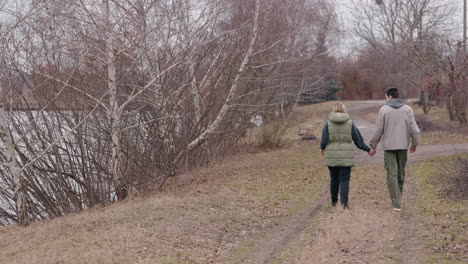 couple walking hand-in-hand in a park