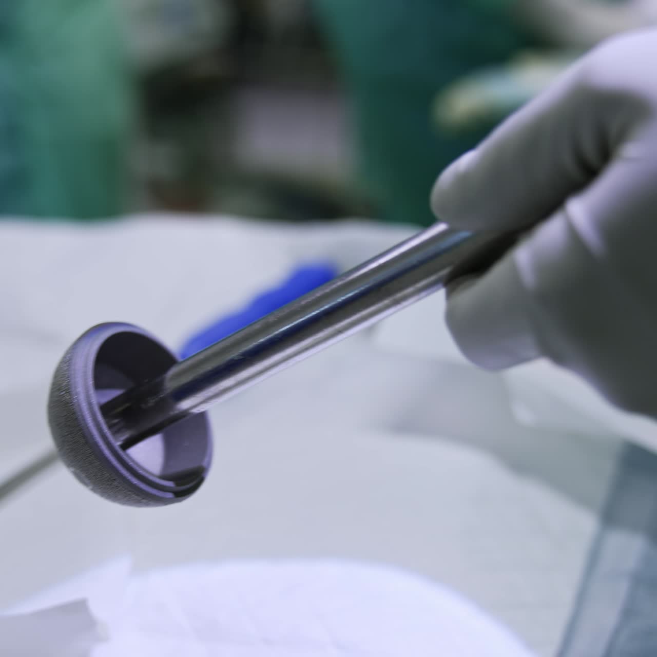 Surgical orthopedic arthroscopic instrument. Diamond milling cutter in the gloved hands of a doctor. Close up. Blurred backdrop
