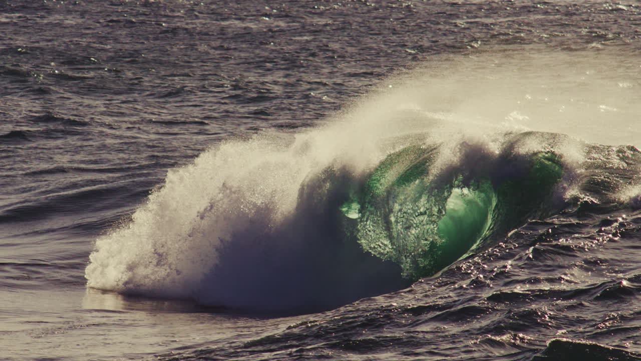 Twilight barrel collapses forward in foamy fold, gentle crash in open ocean perspective