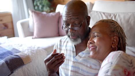 Happy-senior-african-american-couple-talking-sitting-on-floor-at-home,-slow-motion