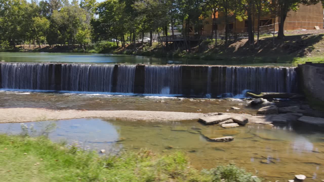 Panorâmica aérea da Cachoeira Buck Creek cercada por subúrbios e lojas de cidade pequena em Old Town Helena, Alabama