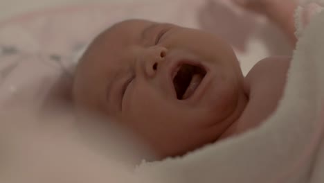 newborn baby girl crying as she is patted dry after bathing- close up shot