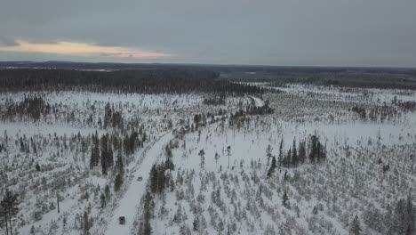 cars driving through a snow covered landscape near kuusamo, finland