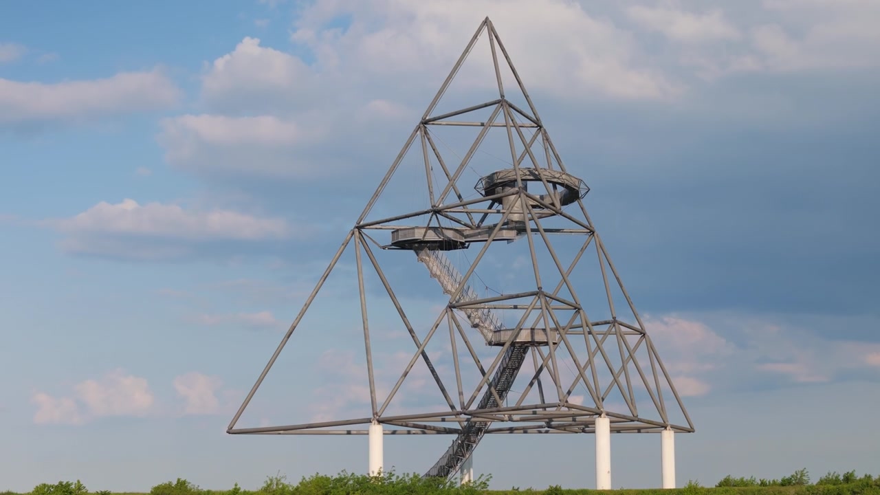 The tetraeder observation tower in bottrop, germany, standing against a partly cloudy blue sky