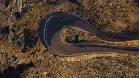 vista aérea de arriba hacia abajo de un ciclista rápido que toma un giro brusco en un paisaje remoto