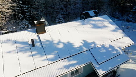 aerial view rising around snowy sunlight collectors, on a house roof, winter day