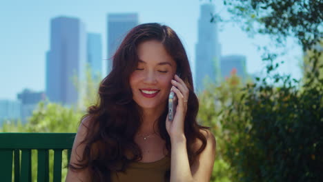 happy woman calling phone in park close up. asian girl use gadget on nature.