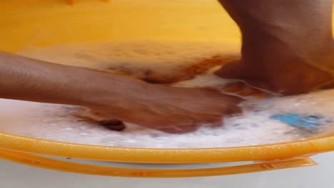 hand washing clothes in a bucket