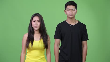 young asian couple giving handshake together