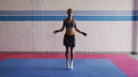 mixed race woman working out in boxing gym