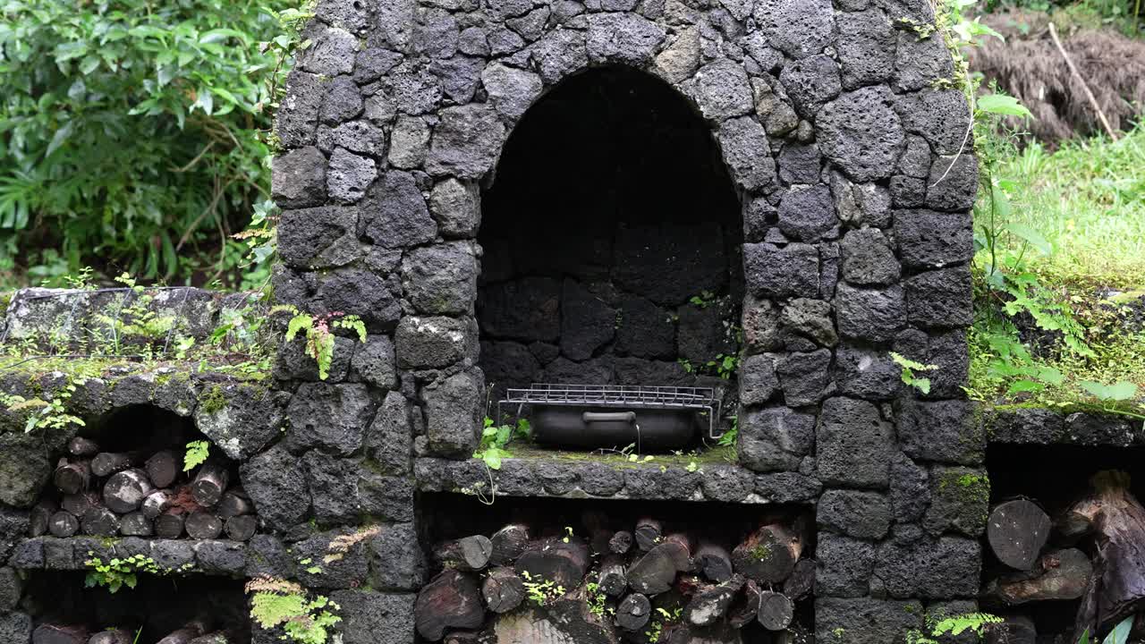 rustic stone barbecue next to cabin