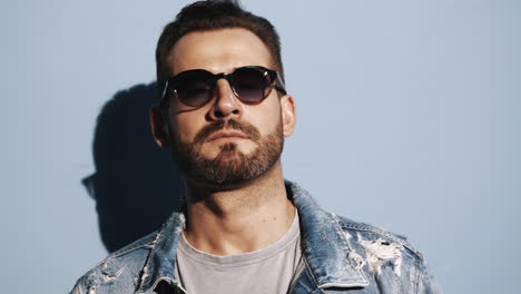 hombre elegante con chaqueta de denim y gafas de sol