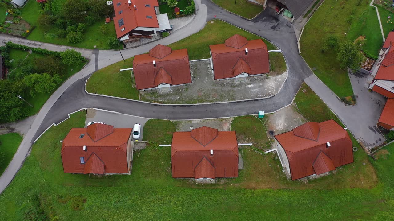 Drone aerial ascending tilt down bird eye view of a small village with cluster of houses