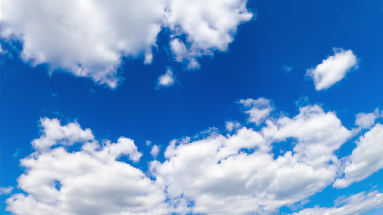 Fluffy soft clouds changing their shape in the skies. Summer blue horizon with cumulus cloudscape. Timelapse.