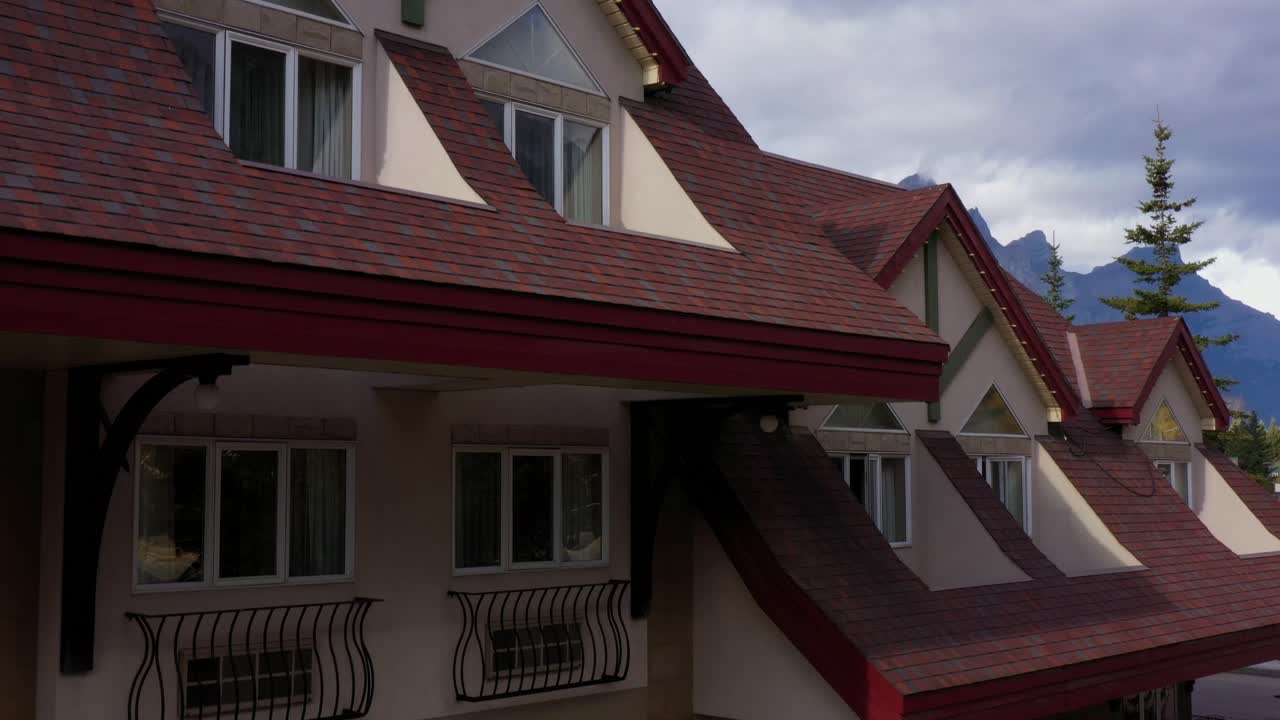 revelación de drones desde un lindo hotel de estilo alpino hasta una gran montaña detrás en el fondo