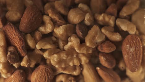 close up shot of different varieties of nuts spinning in glass, walnut,almond,cashew nuts