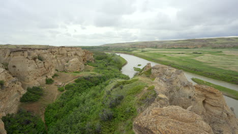 Bandlands-and-Hoodoos-with-river-in-a-desert-in-Alberta,-Canada-during-overcast-day