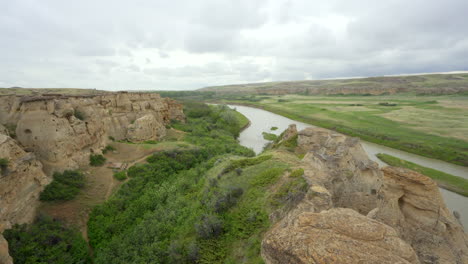 bandlands y hoodoos con río en un desierto en alberta, canadá durante el día nublado