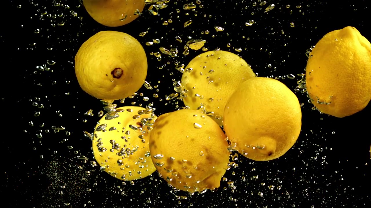 Limoni gialli freschi immersi nell'acqua con bolle